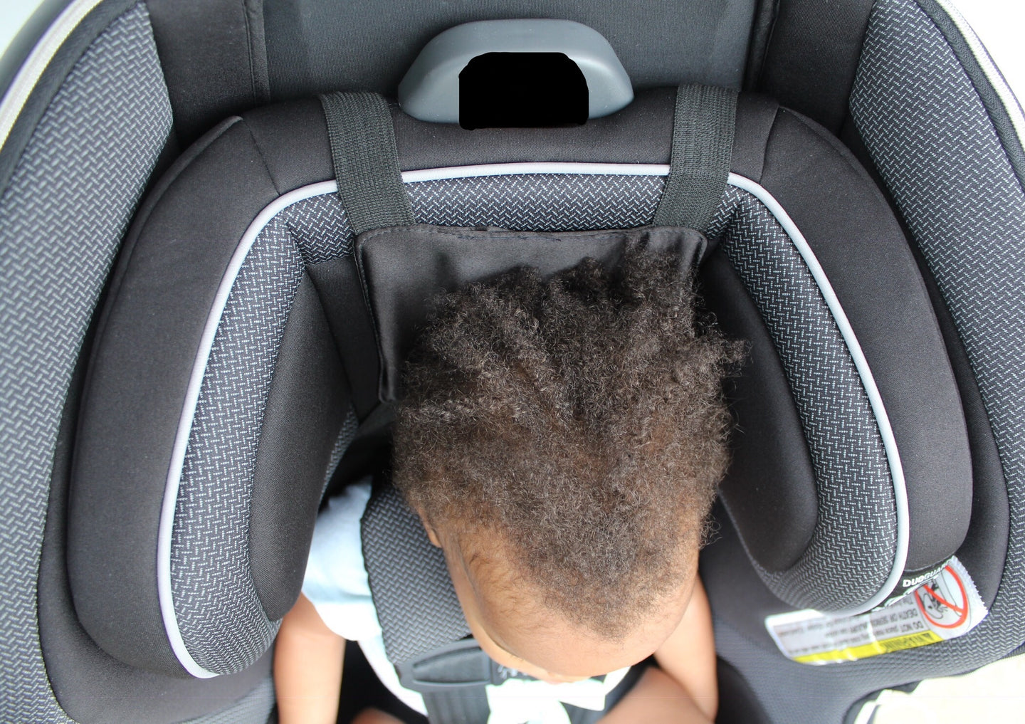 Sleadrest™ (Satin-lined headrest) installed on a child's car seat to prevent dry hair and hair breakage.